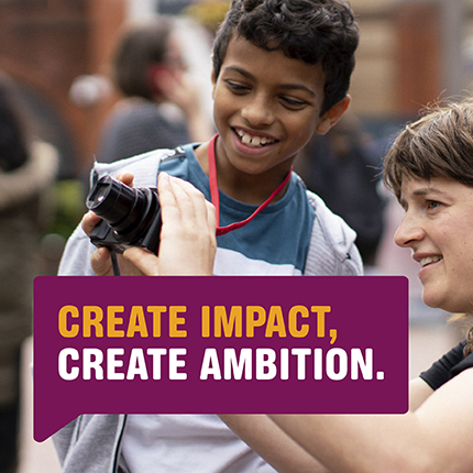 Charity worker showing child how to use camera 