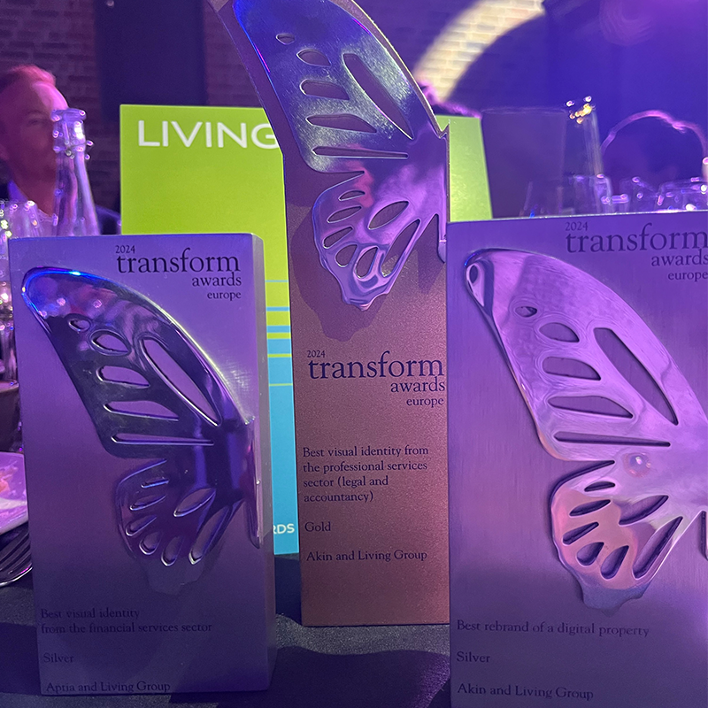 Four Transform awards on table with a hazy purple background tint 